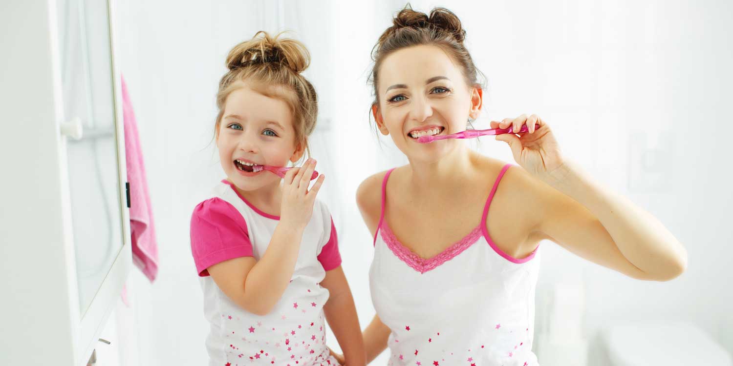 Mother and Daughter are Brushing Their Teeth